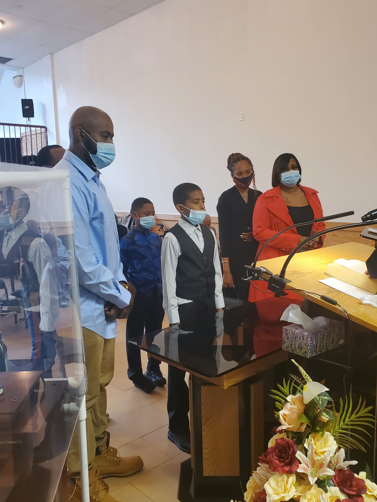 a group of people wearing face masks are standing in front of a podium .