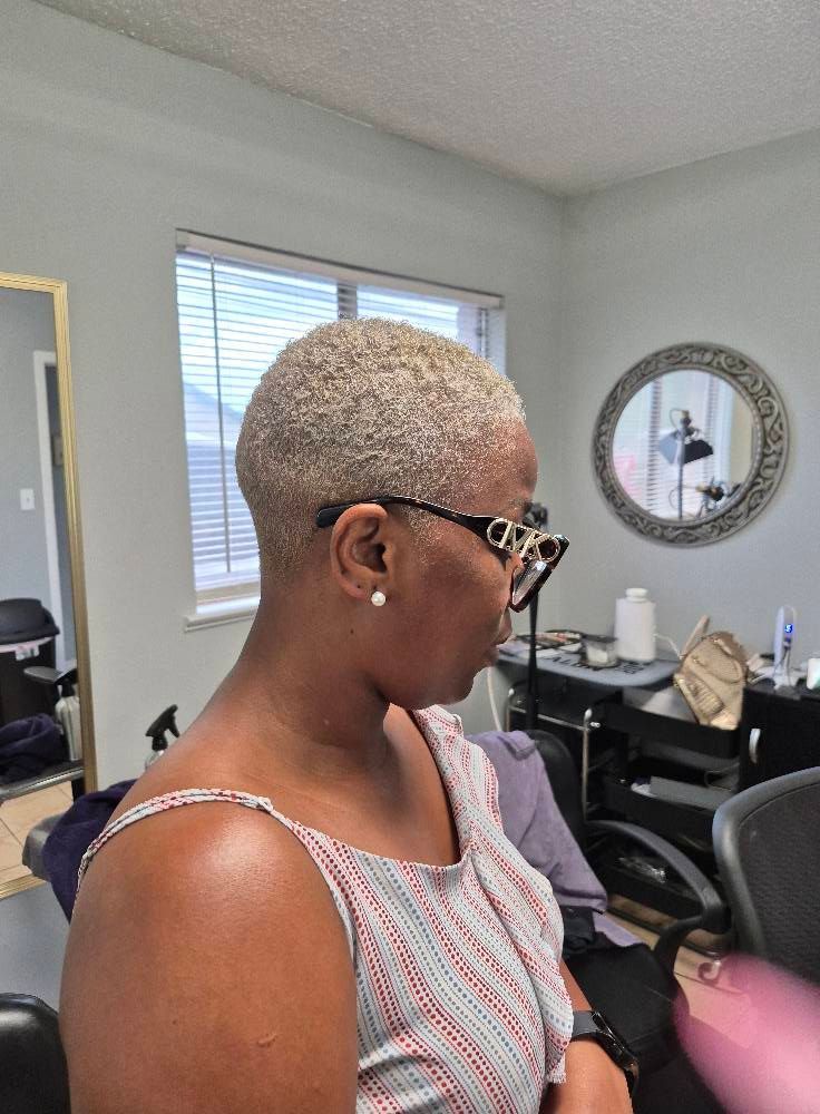 Woman with short, light-colored hair wearing glasses in a salon setting.