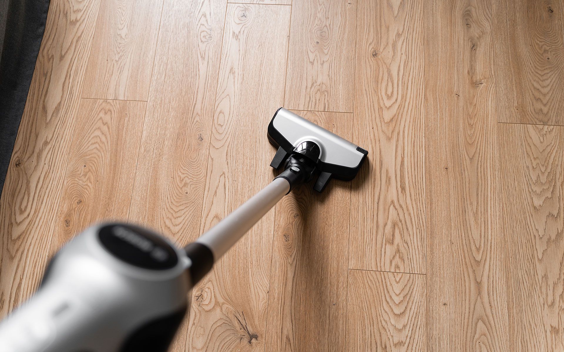 Vacuum cleaner cleaning a hardwood floor.
