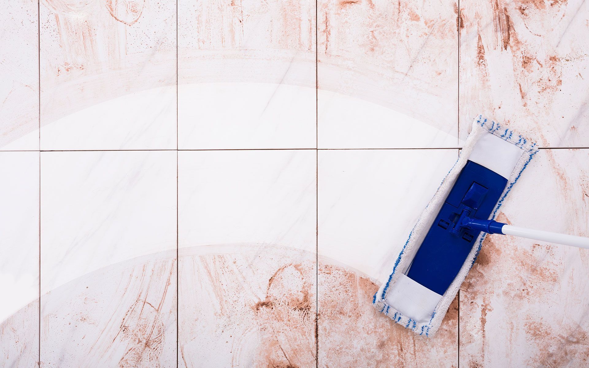 White and blue mop cleaning light brown tiled floor.