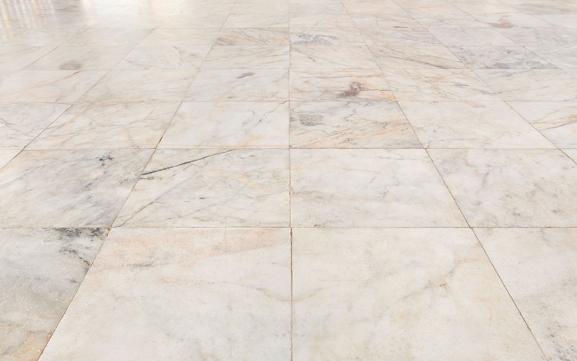 Cream and gray marble tiled floor, perspective view.