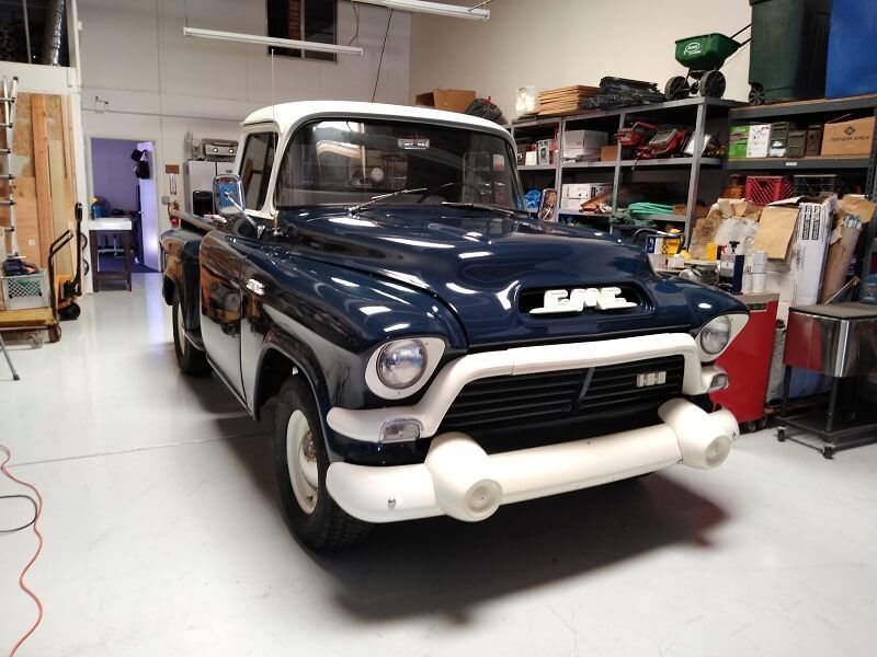 a blue and white gmc truck is parked in a garage