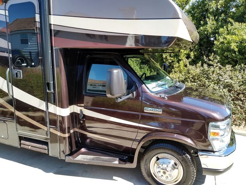 a brown rv is parked on the side of the road