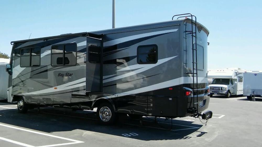 a large rv is parked in a parking lot .