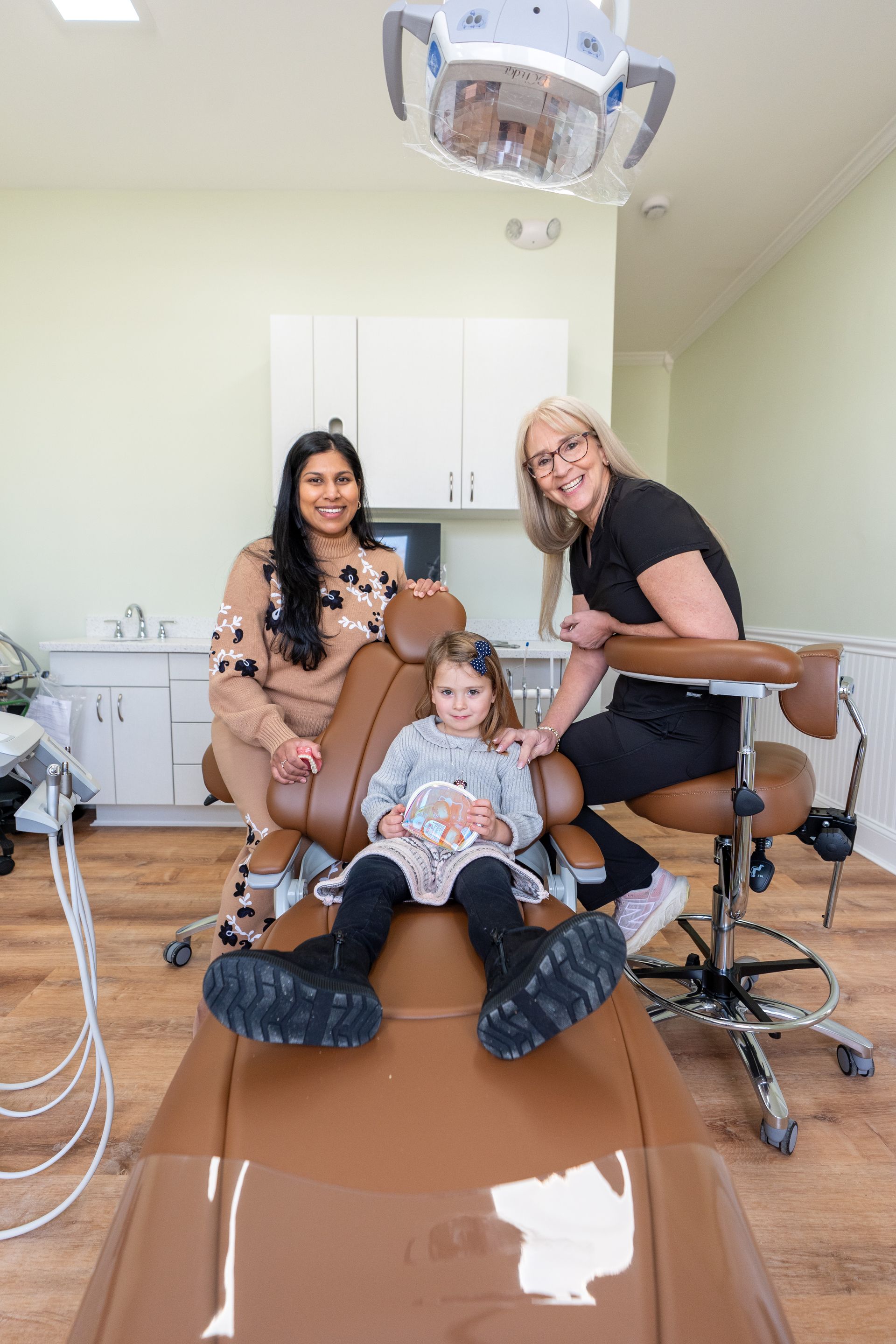 Young person smiling while having dental X-ray taken.