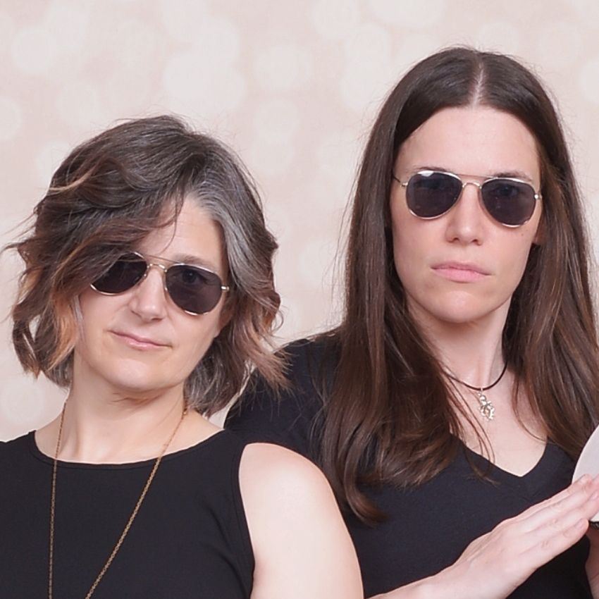 andrea tarka white smiling and leaning on a table