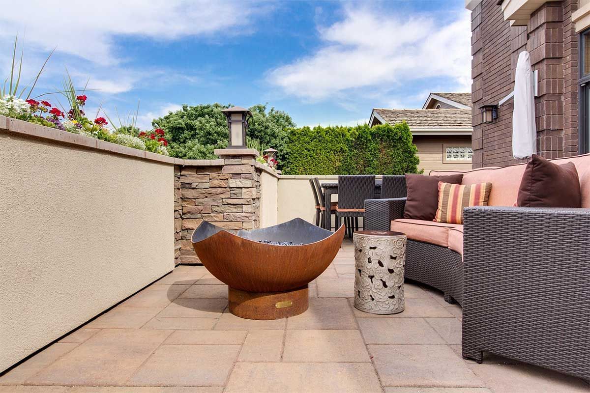 A stamped and colored concrete patio with furniture.