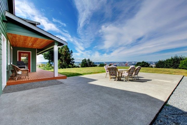 A large, basic concrete patio with furniture in a Colorado backyard.