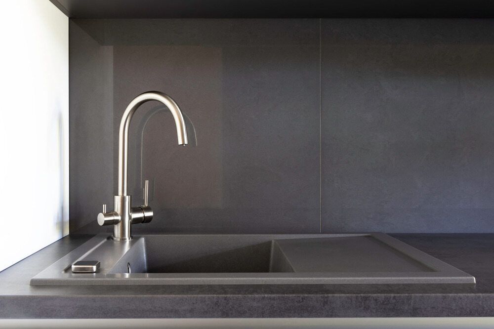 A Kitchen Sink With A Stainless Steel Faucet And A Black Counter Top — Colonial Sheet Metal in Garbutt, QLD