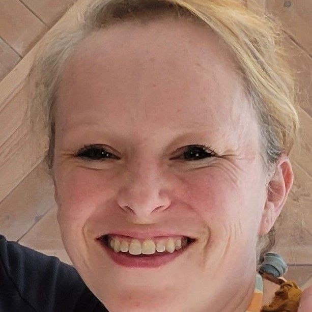 A close up of a woman 's face with a smile on her face.