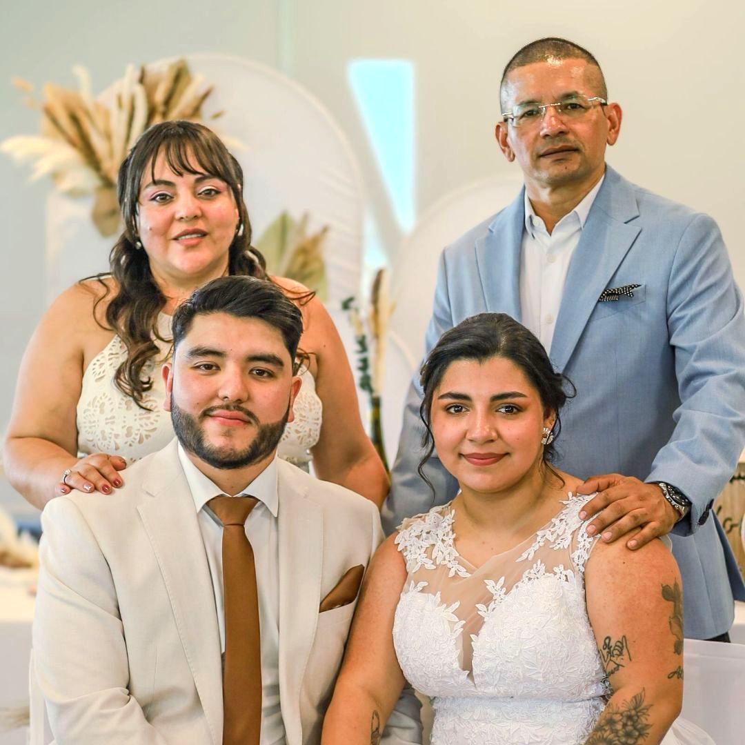 Un groupe de quatre personnes souriantes posent pour un portrait formel.