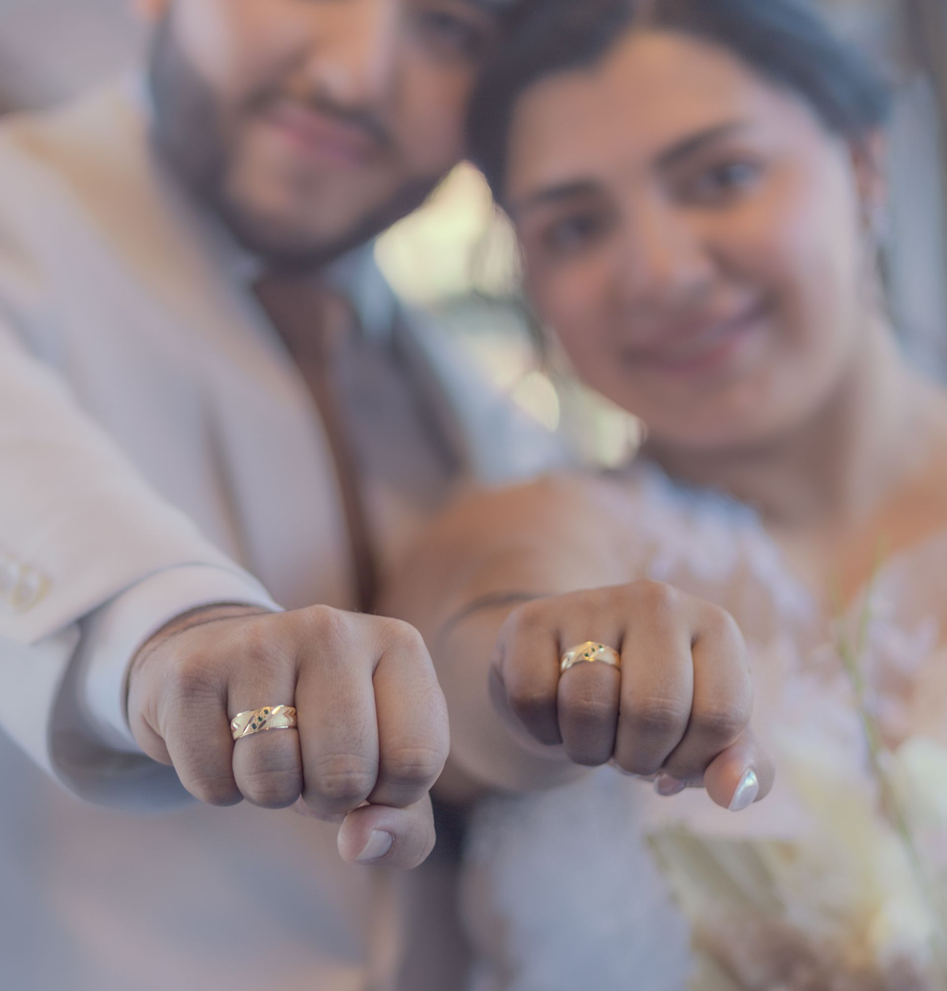 Couple exhibant ses alliances, poings en avant, sourires.