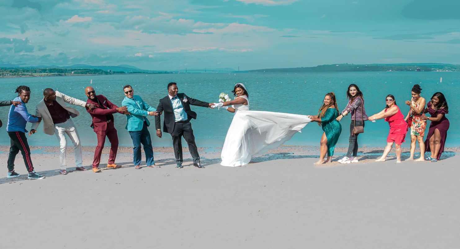 Un groupe de personnes se tient sur une plage et se tient la main.