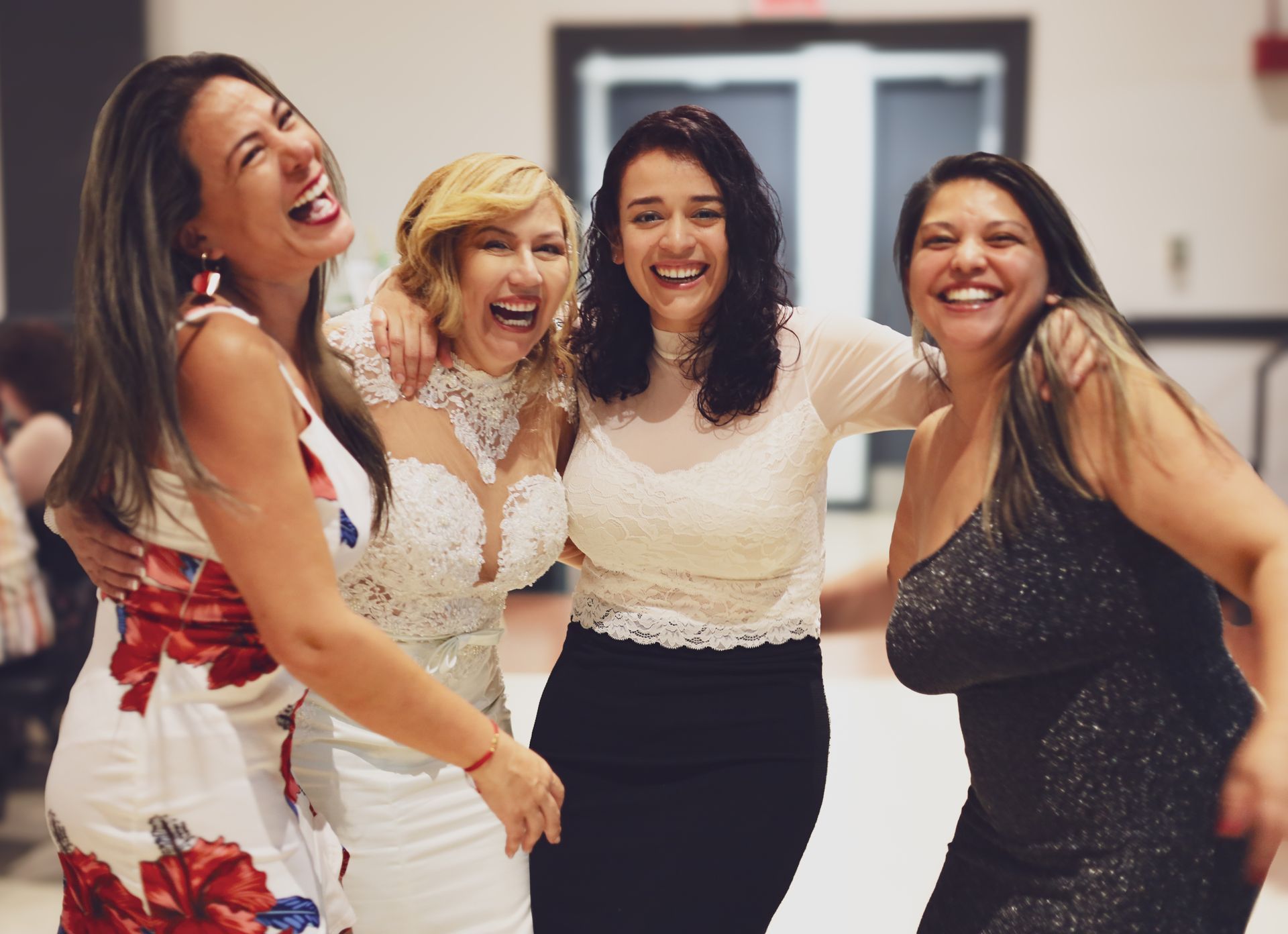 Un groupe de femmes posent ensemble pour une photo et rient.