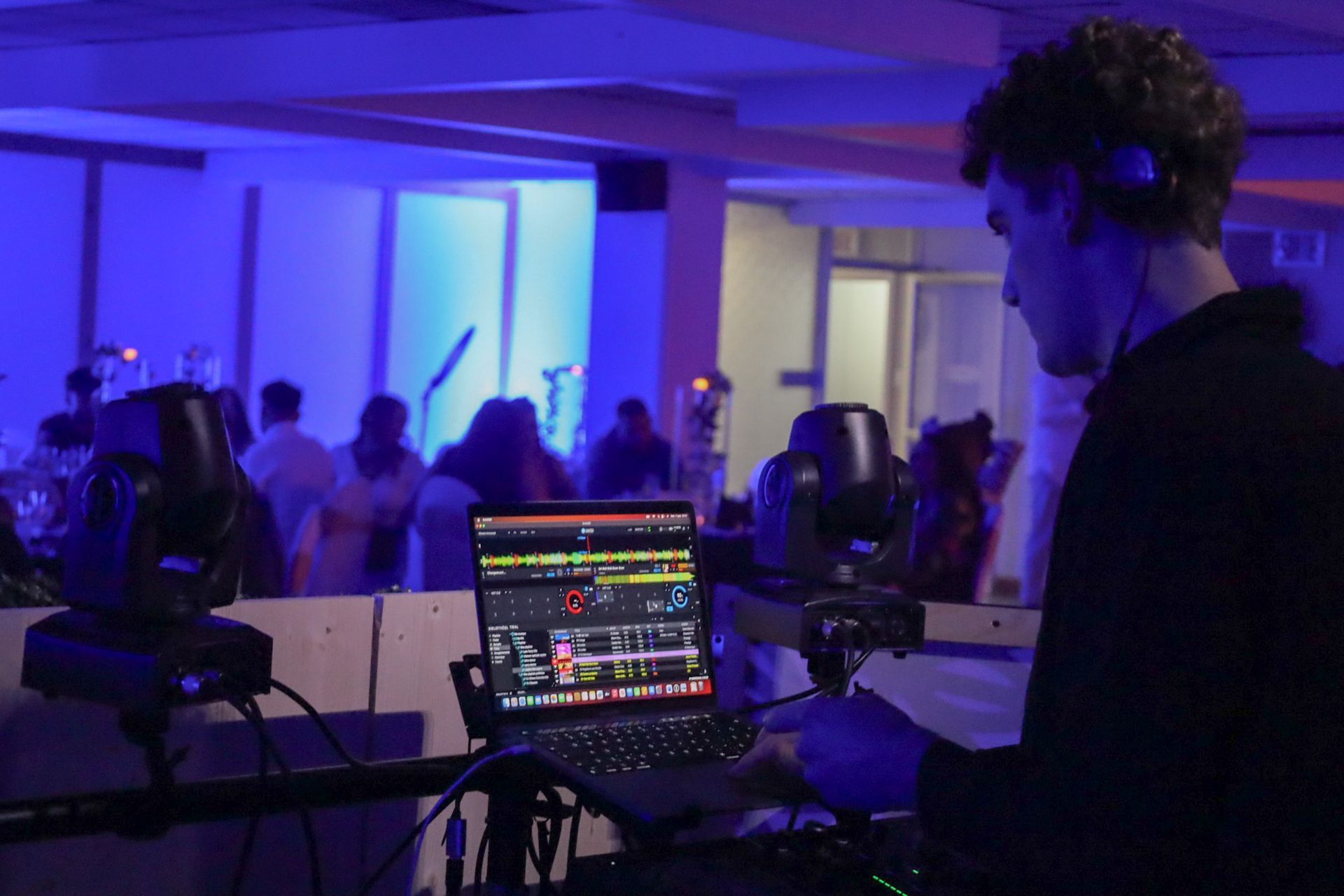 Un homme joue de la musique sur un ordinateur portable lors d'une fête.