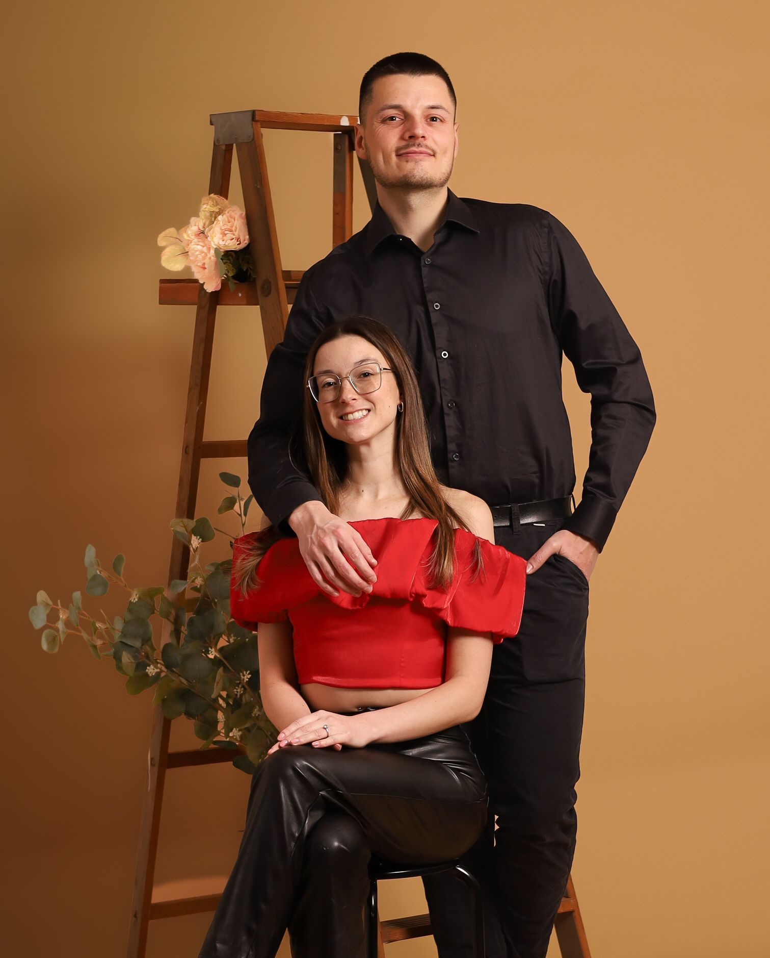 Un homme et une femme posent pour une photo devant une échelle.