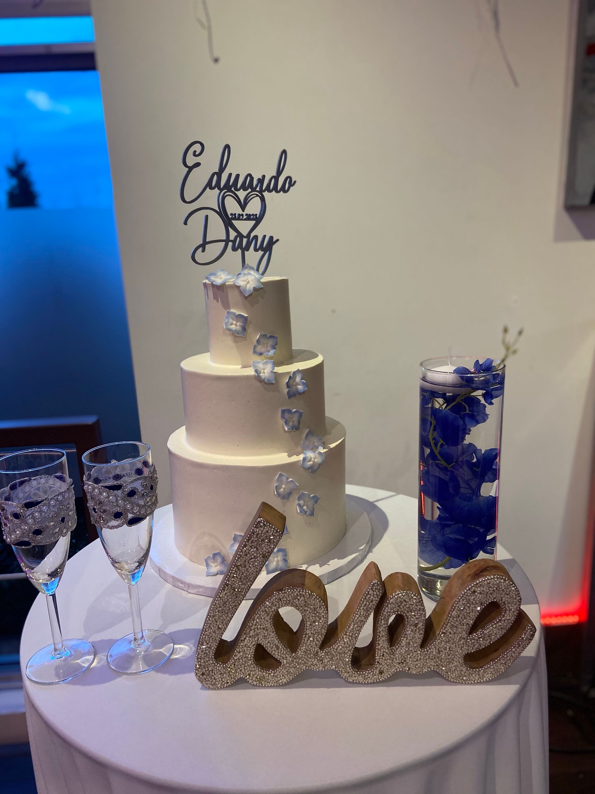Un gâteau de mariage est sur une table à côté d'un panneau sur lequel est écrit amour