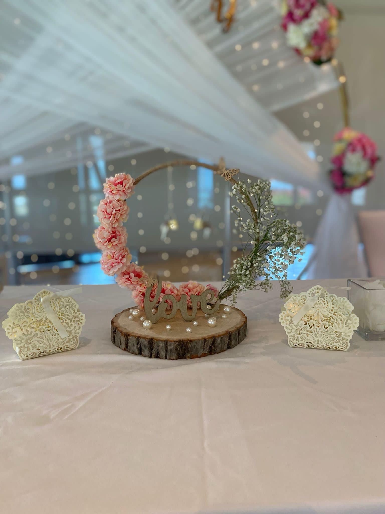 Une table avec des fleurs et une tranche de bois dessus.