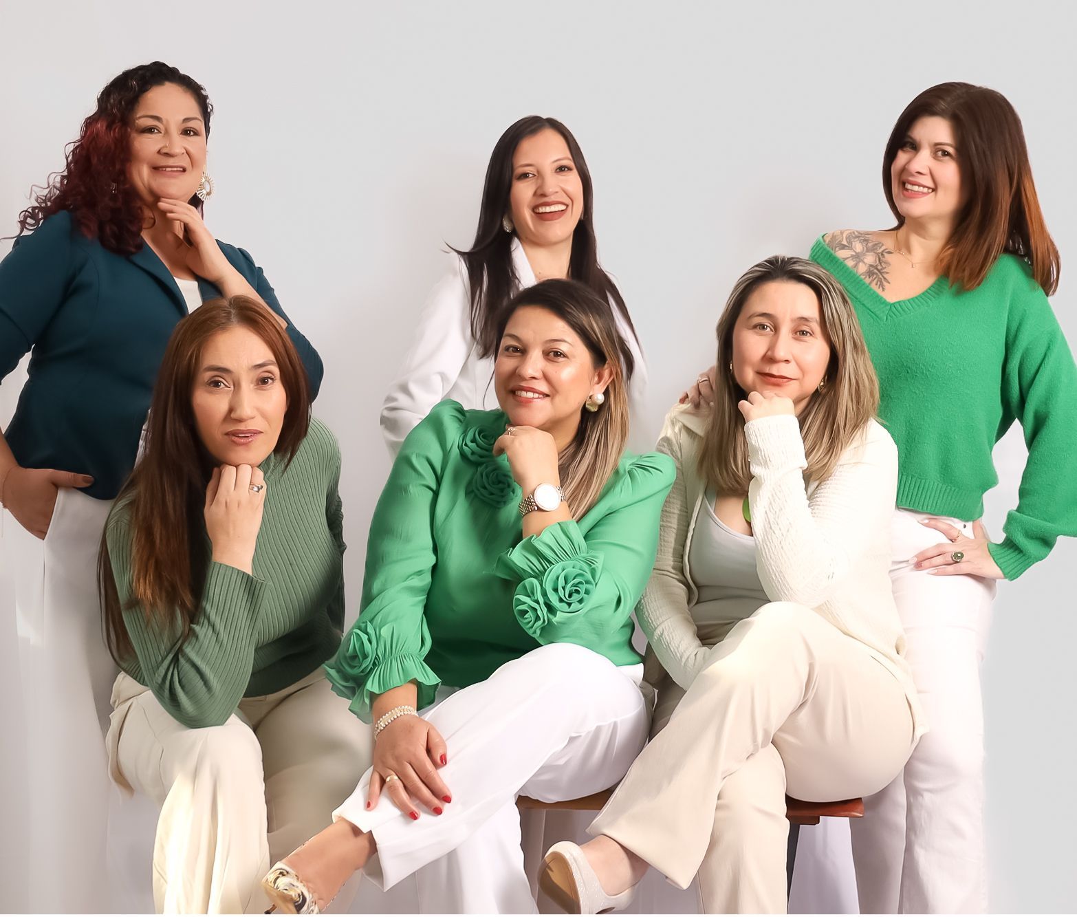 Six femmes posant ensemble, vêtues de vert et de blanc, souriantes, en studio.
