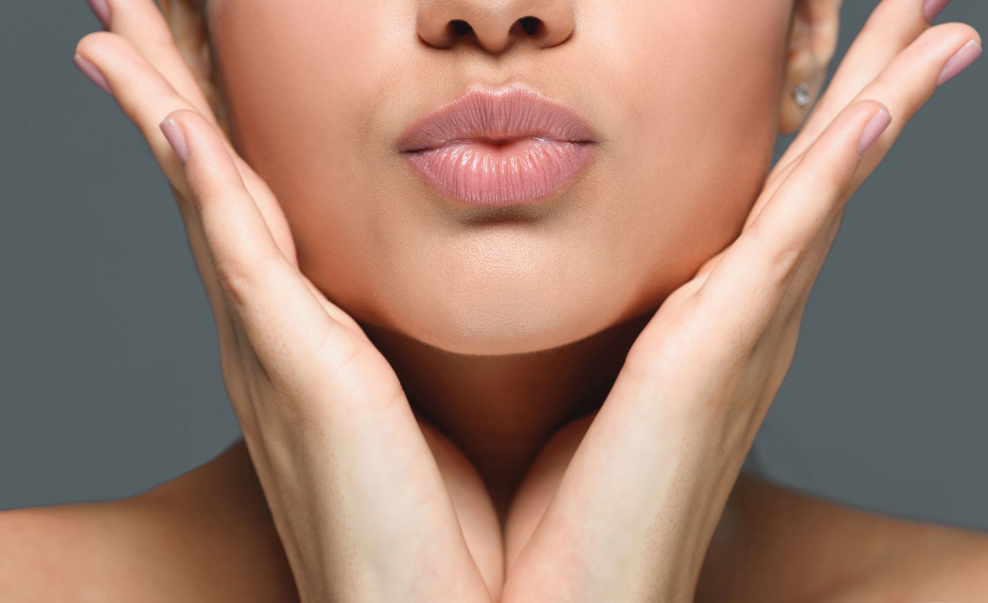 Woman showing her full lips after a lip filler treatment at Compass Light Med Spa in Cohasset.