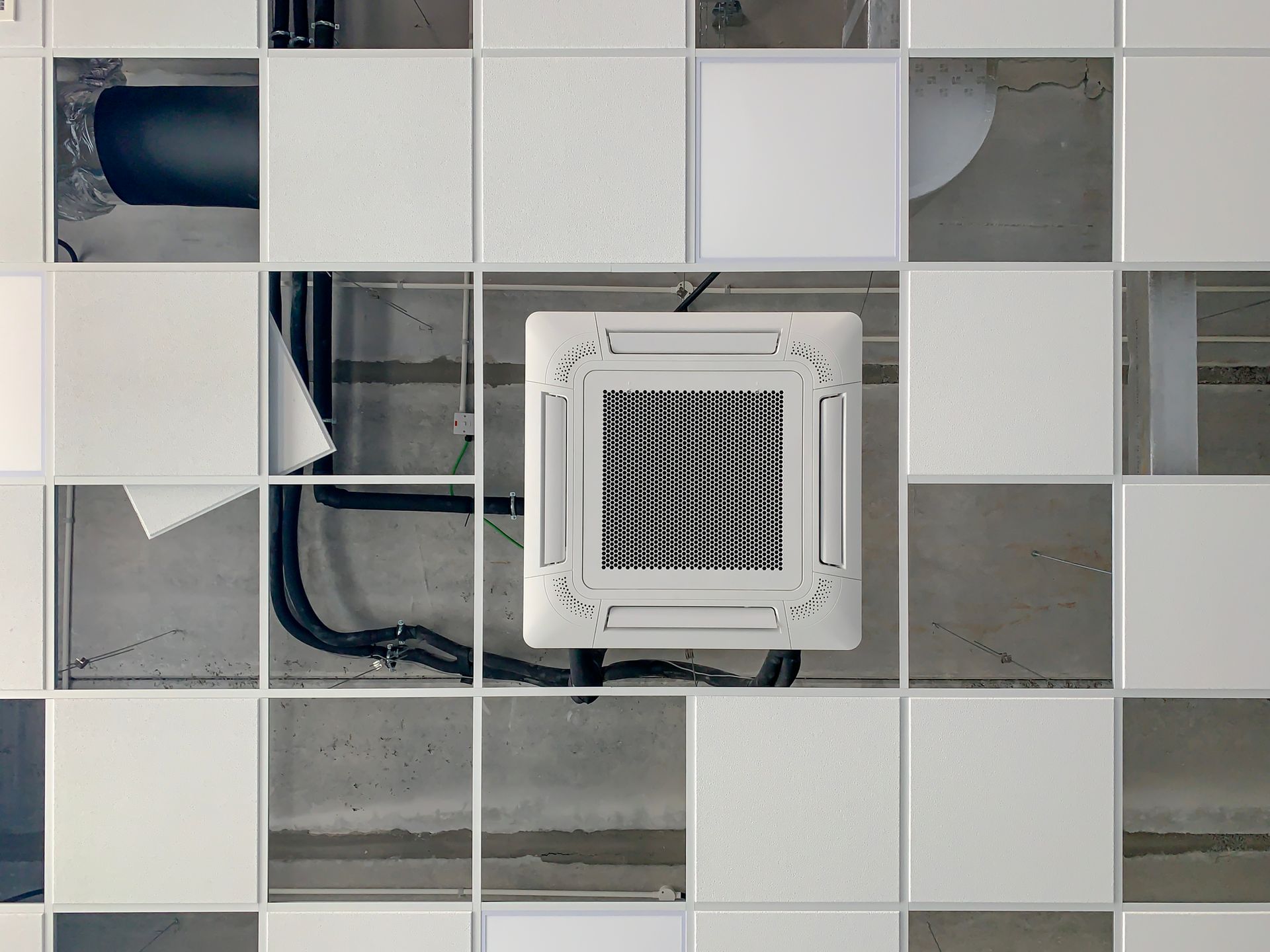 Low-angle view of incomplete ventilation installation works to a false ceiling.