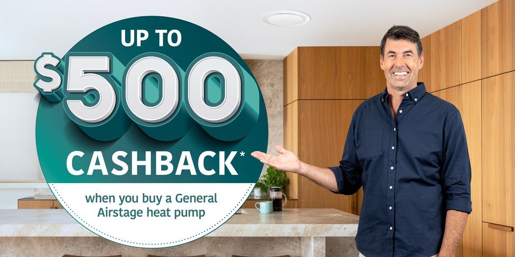 Man in navy shirt presenting a sign that says “Up to $500 Cashback” in a modern kitchen