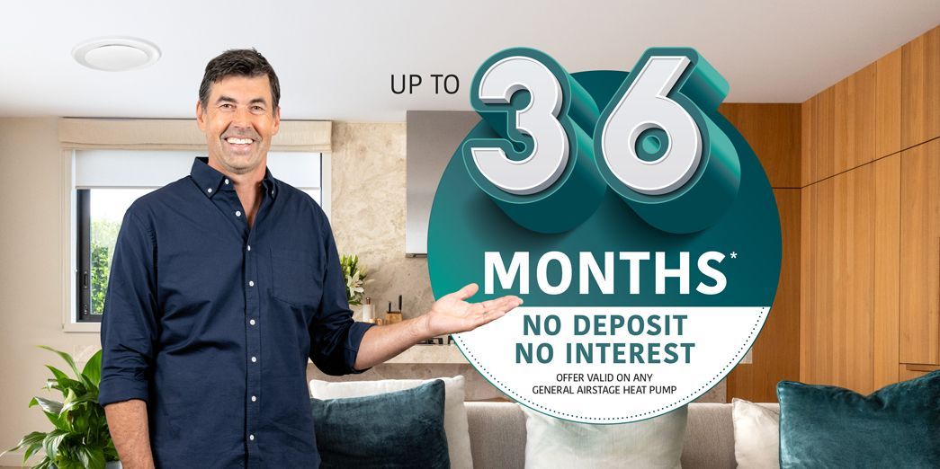 Man standing beside a teal sign reading “36 months” and “No deposit, no interest” in a bright room