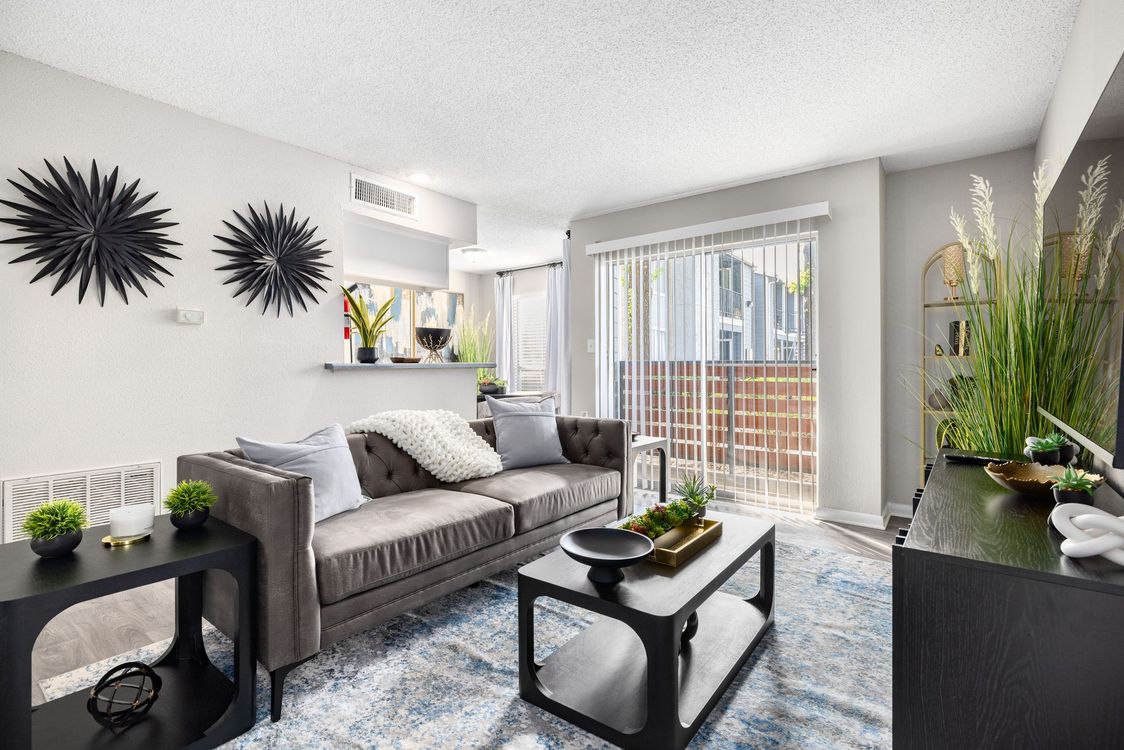 A bedroom with a bed , chair , nightstand and ceiling fan.