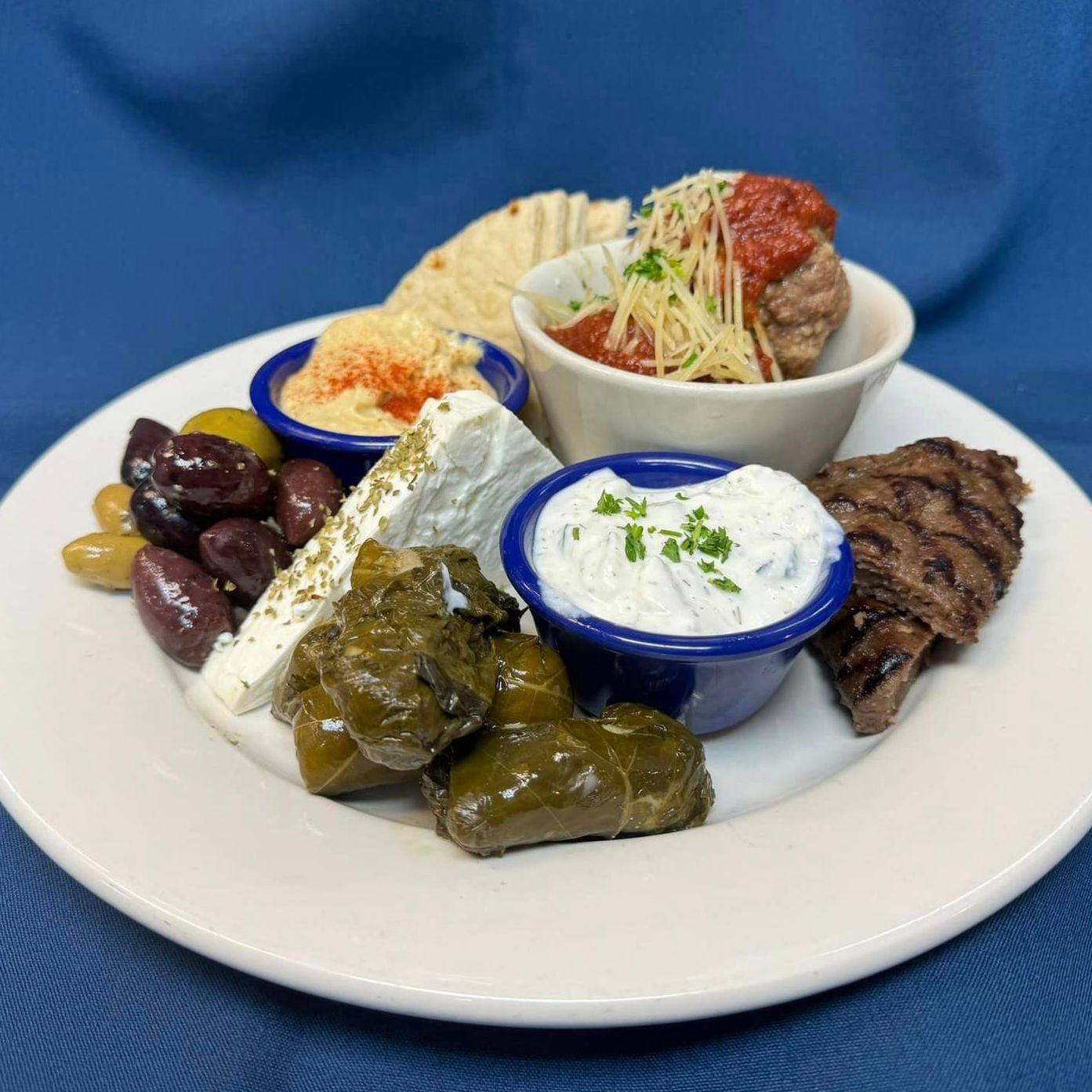 A white plate topped with a variety of food and sauces from Jake and Telly's