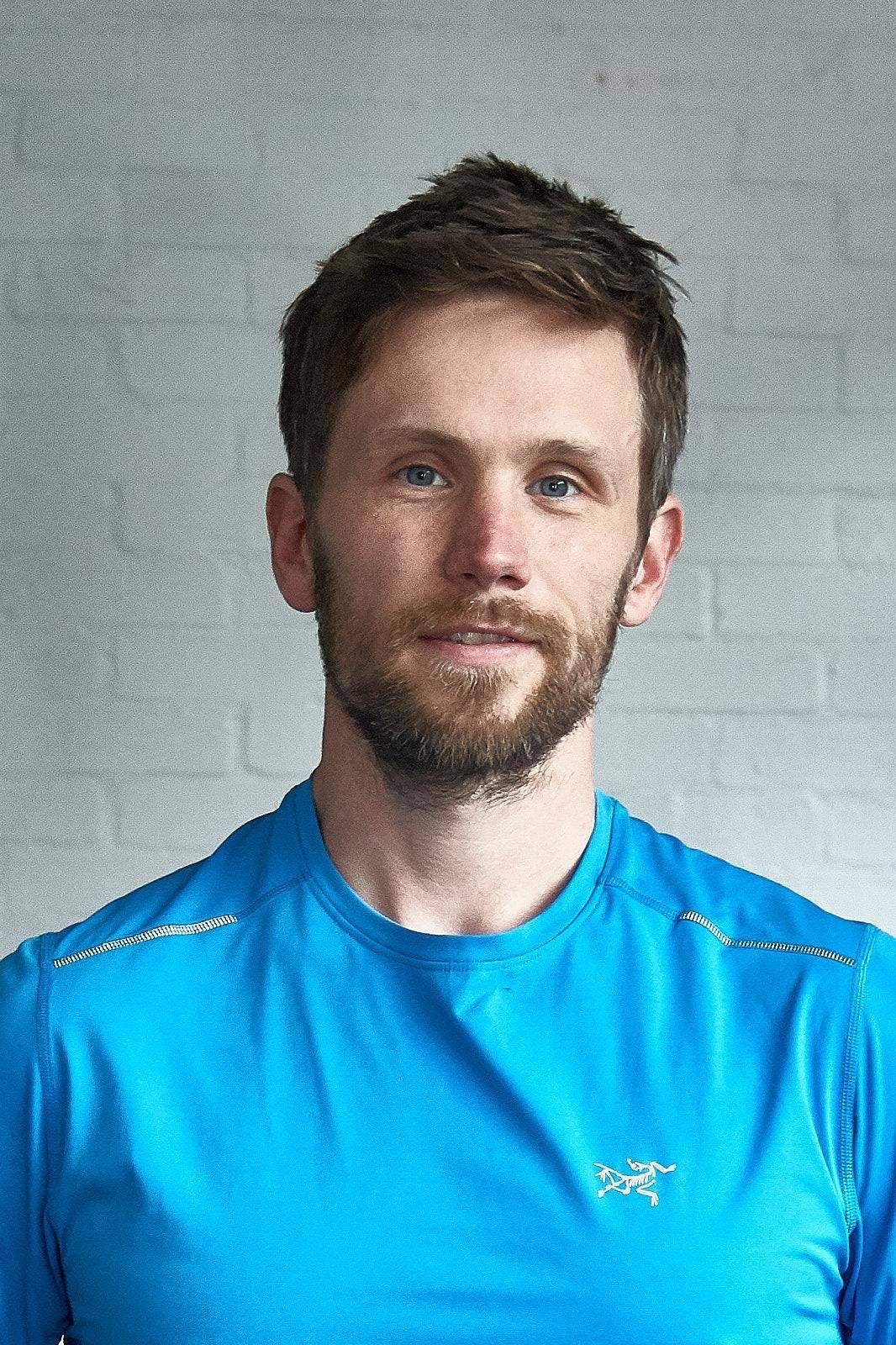 A man with a beard is wearing a blue shirt.