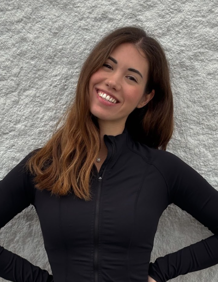 The woman is wearing a black jacket and smiling for the camera.