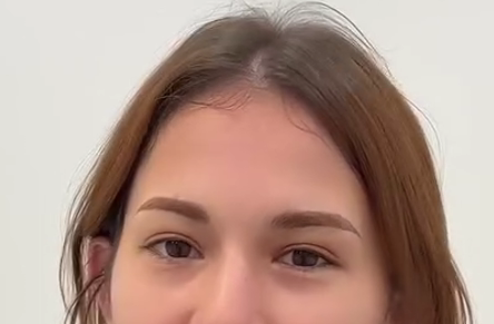 Person covering eyes with hands; neutral expression.