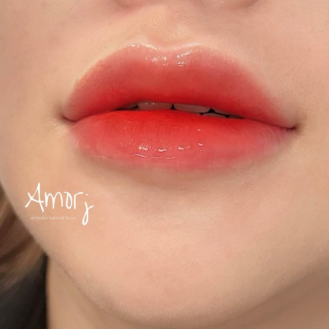 Close-up of lips with a gradient red lip color and glossy finish.