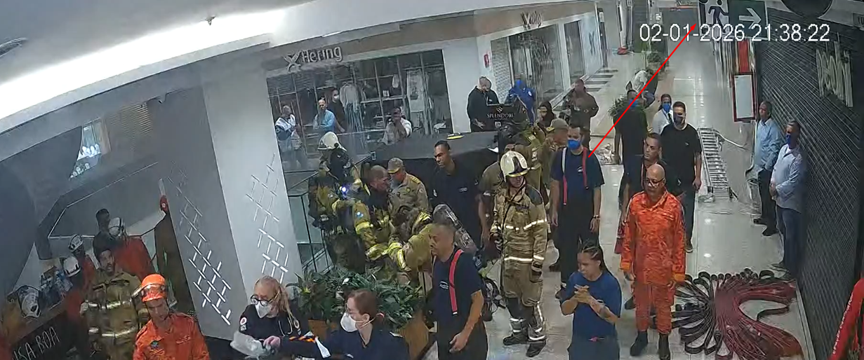 Emergency responders in uniform and protective gear gathered in a brightly lit indoor space, possibly a shopping mall.