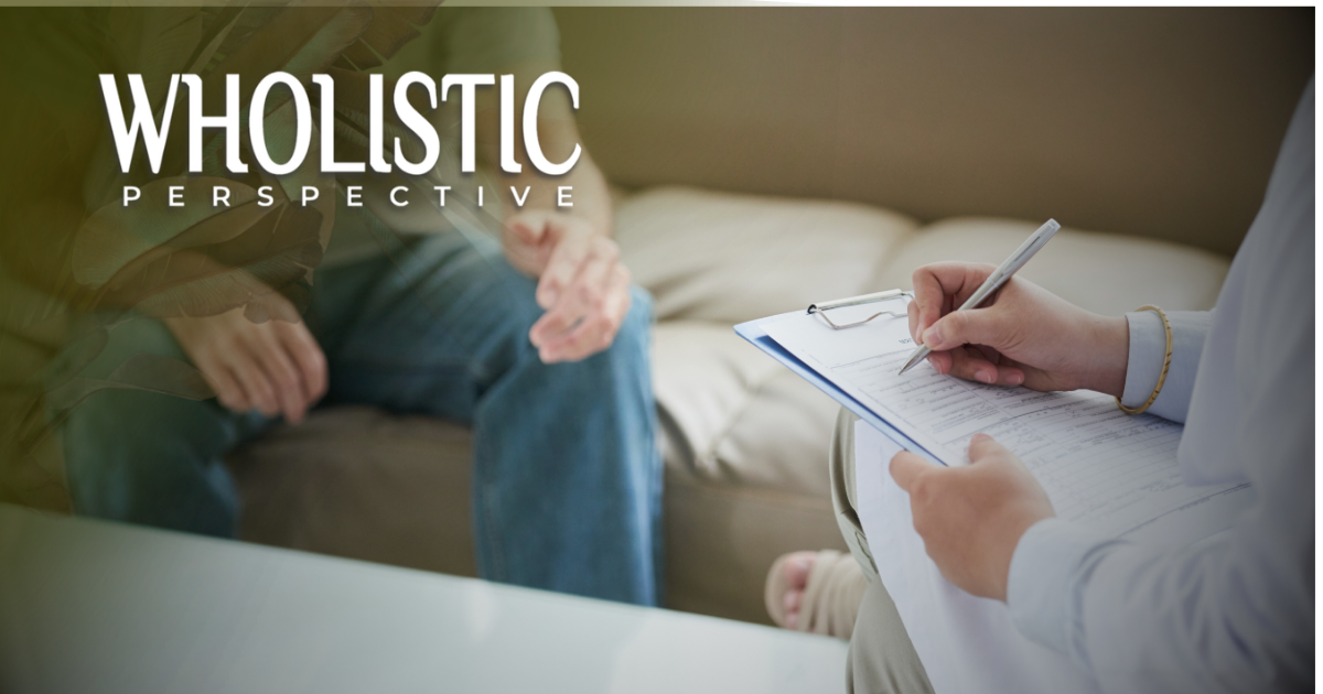A person takes notes on a clipboard during a counseling session with another person sitting across from them.