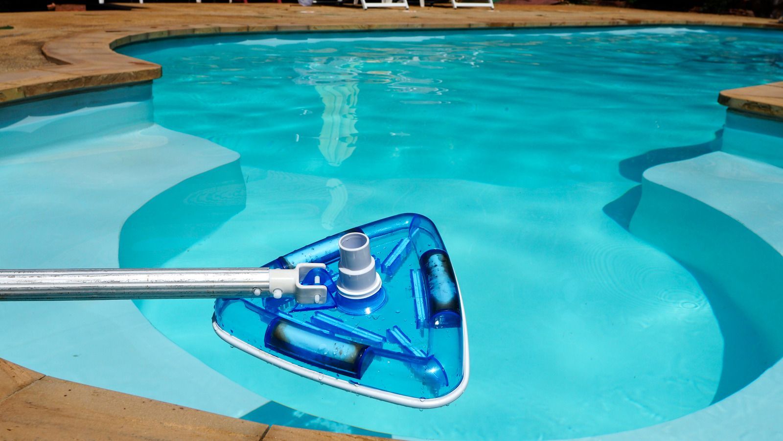 A vacuum cleaner is being used to clean a swimming pool.