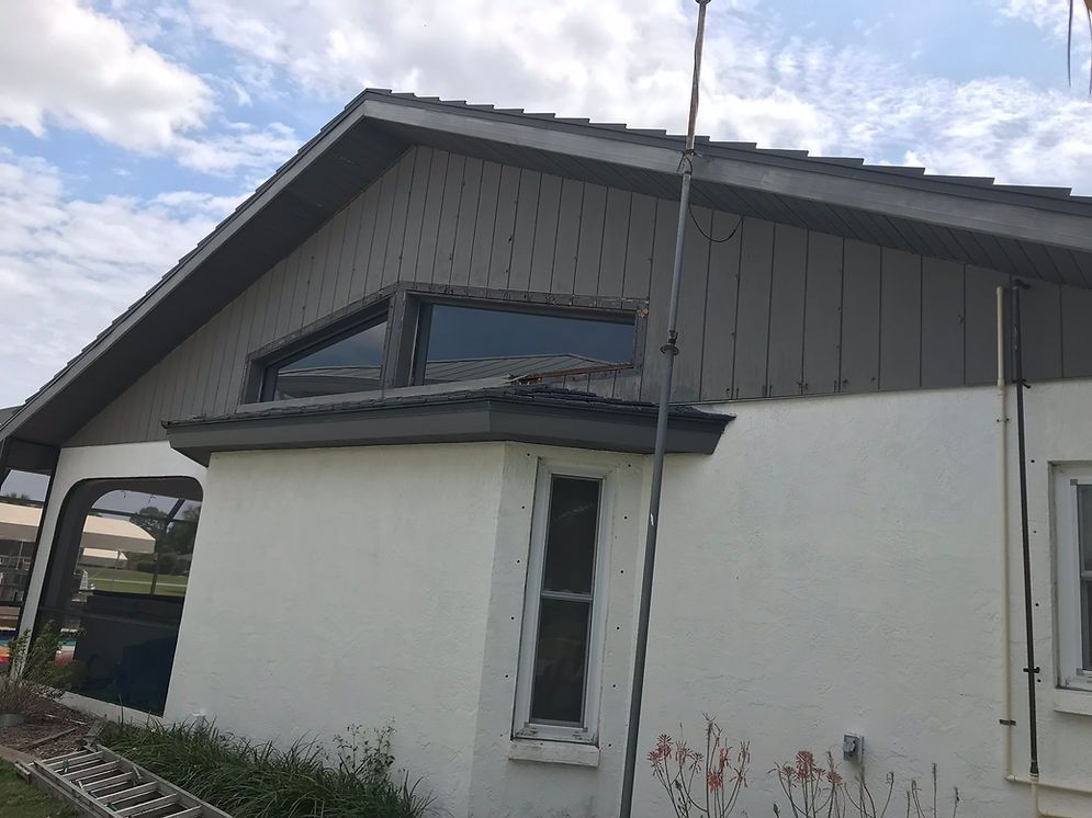 A white house with a gray roof and a window