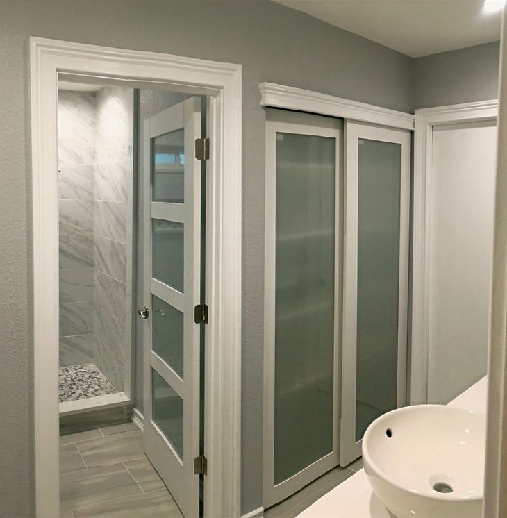 A bathroom with sliding glass doors and a sink.