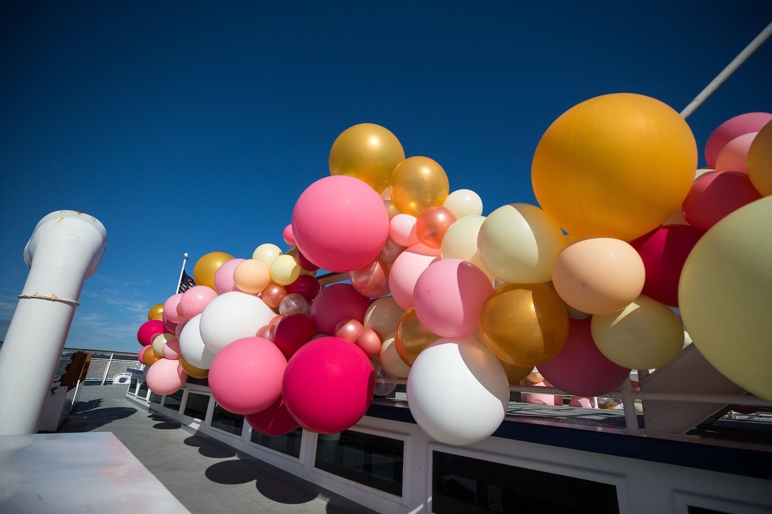 A bunch of balloons are sitting on top of a boat.