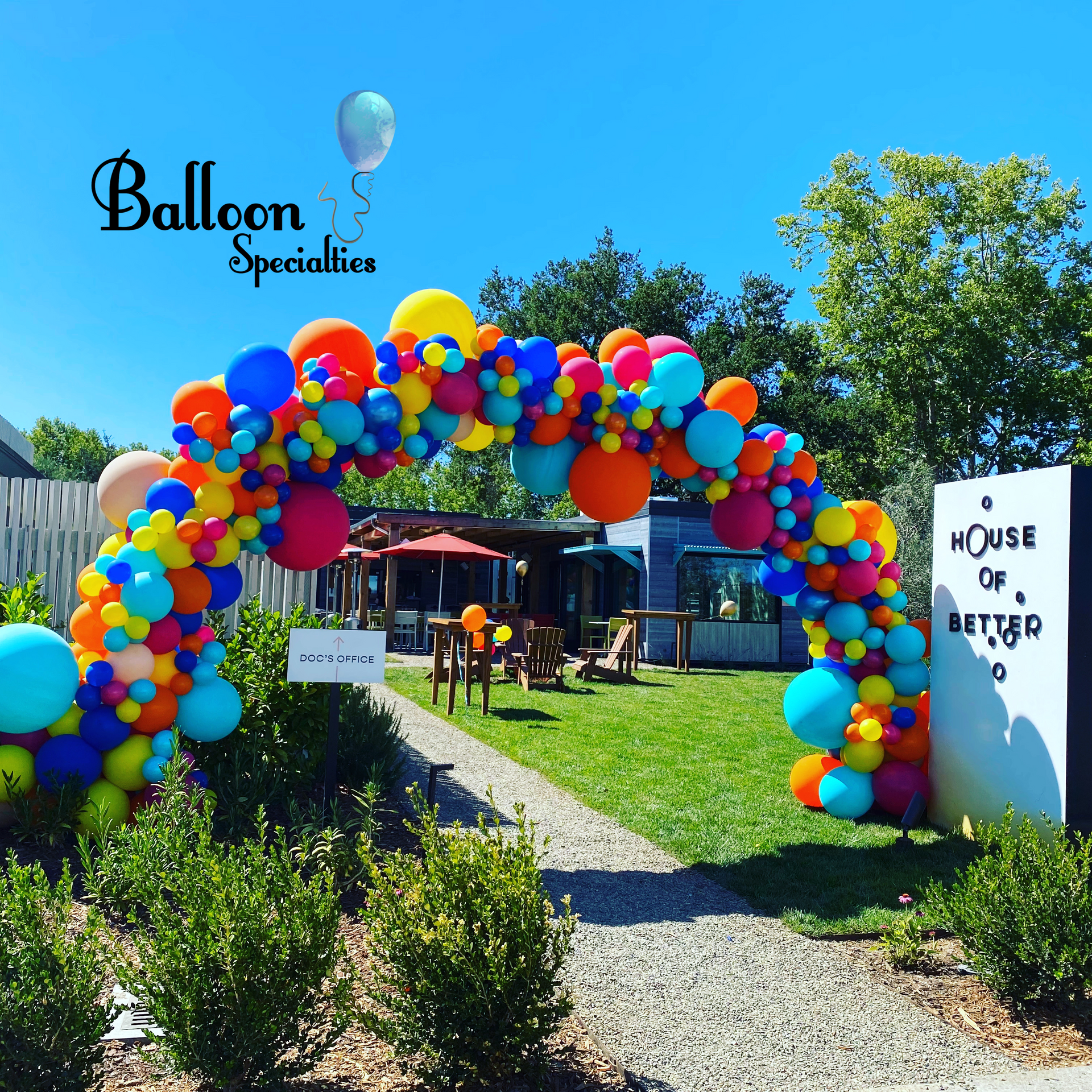 A sign that says house of better is surrounded by balloons