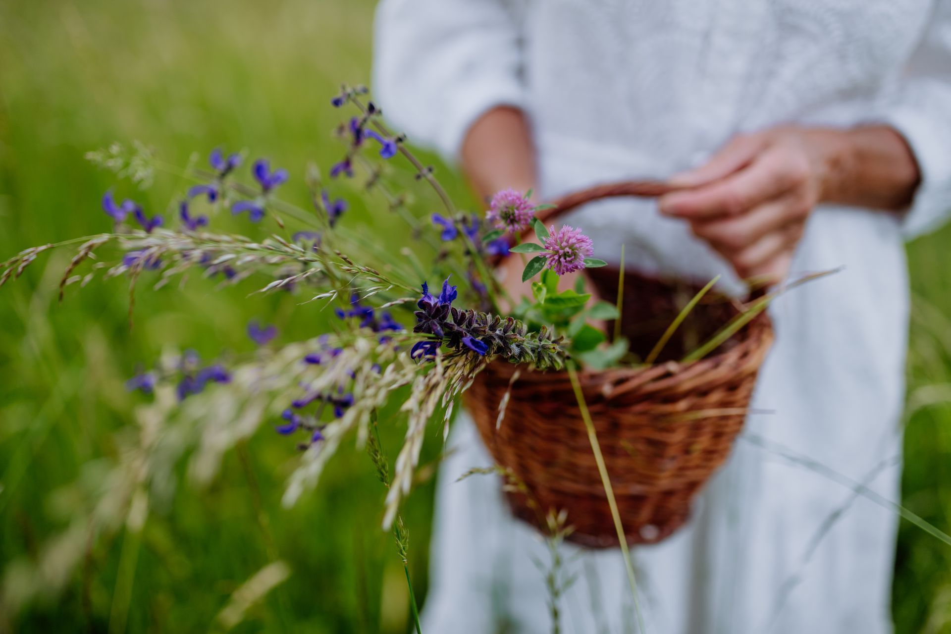 Eine Frau steht mit ausgestreckten Armen auf einem Feld
