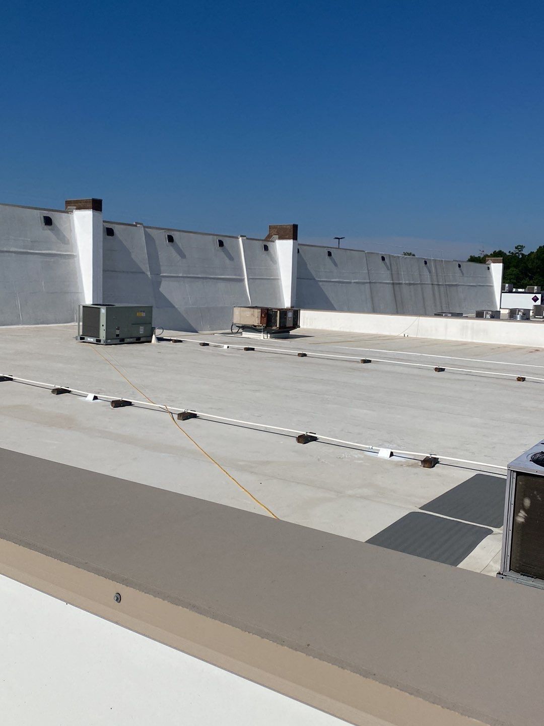 Commercial roofing project in progress with workers installing a new roof.