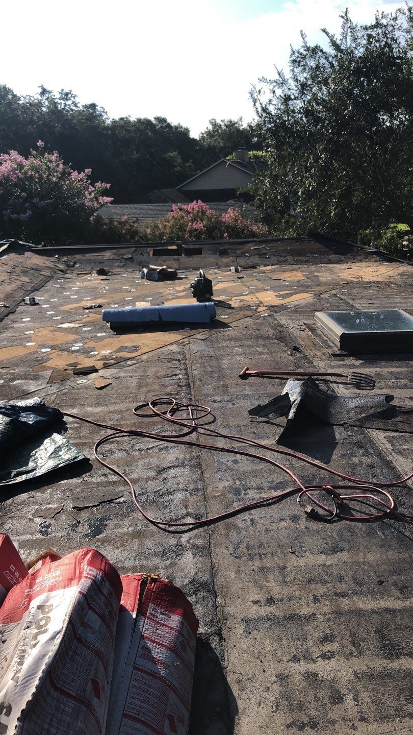 Commercial roofing project in progress with workers installing a new roof.