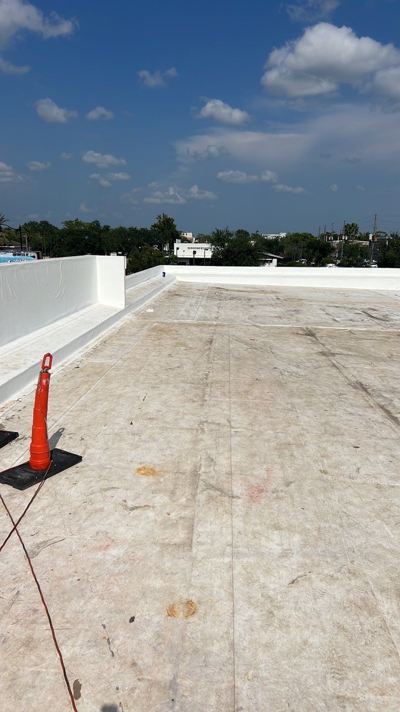 applying single ply roofing material on a flat roof. Commercial roofing project in progress with workers installing
