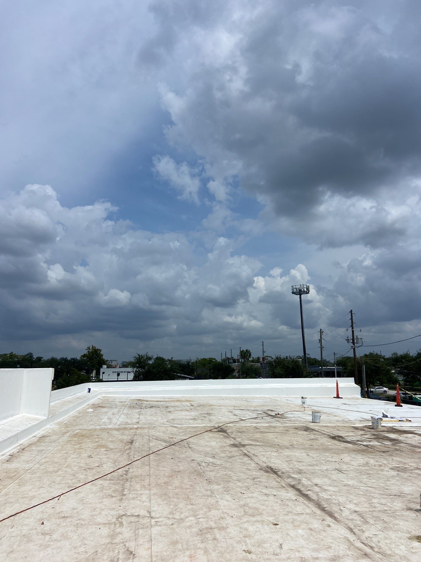 Technician applying single ply roofing material on a flat roof. Commercial roofing project in progress 