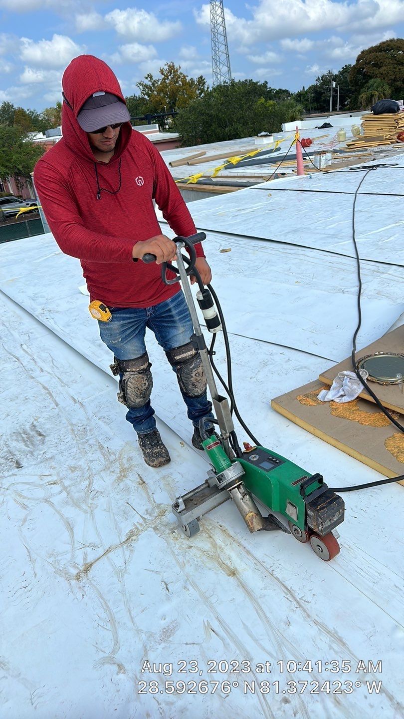 Commercial roofing project in progress with workers installing a new roof.