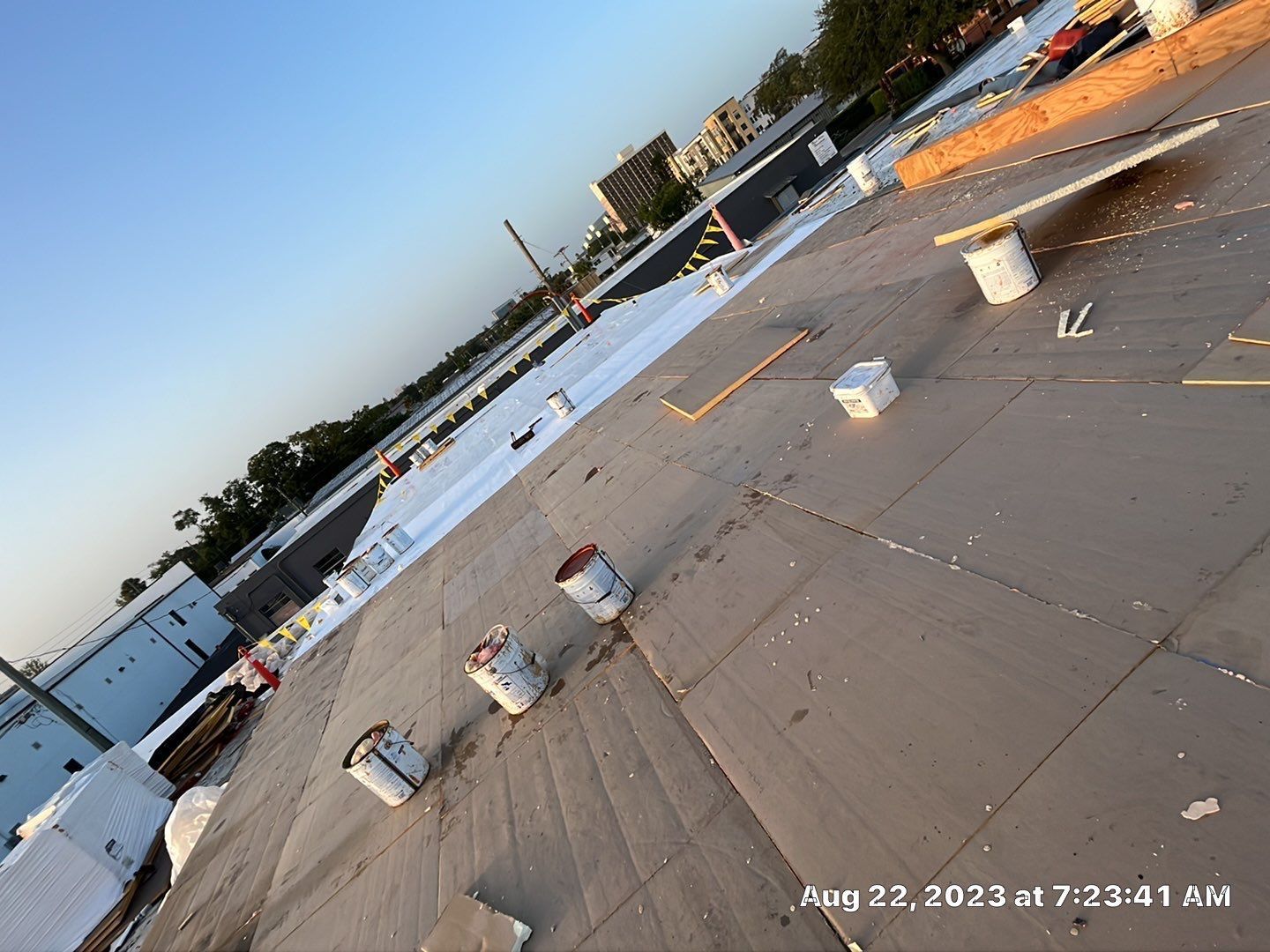 Technician applying single ply roofing material on a flat roof. Commercial roofing project in progress 
