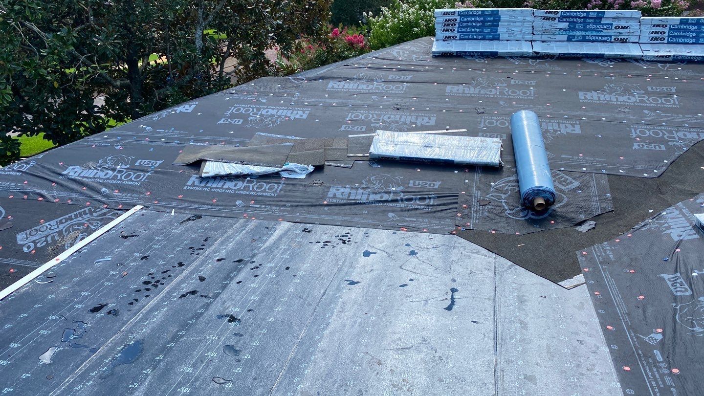 Roofers applying modified bitumen roofing material for added protection.