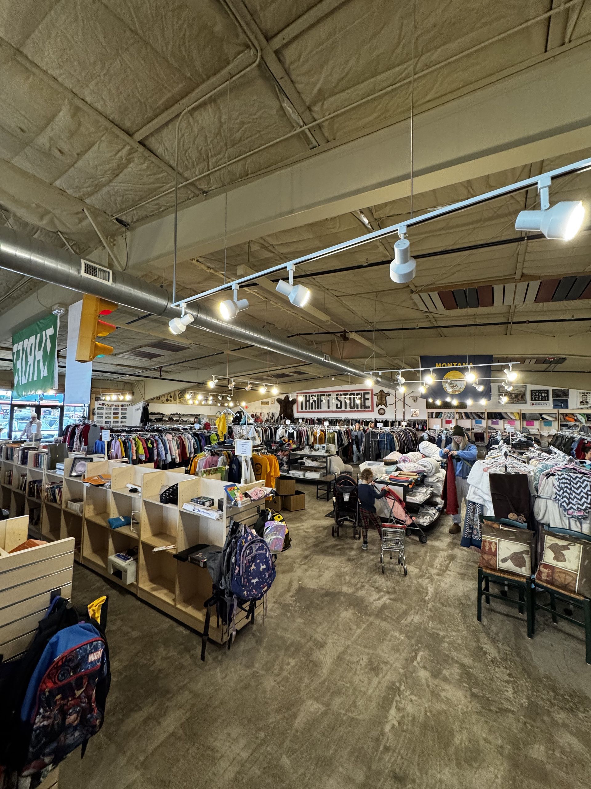 Interior of a retail store with clothing racks, displays, and overhead lighting.