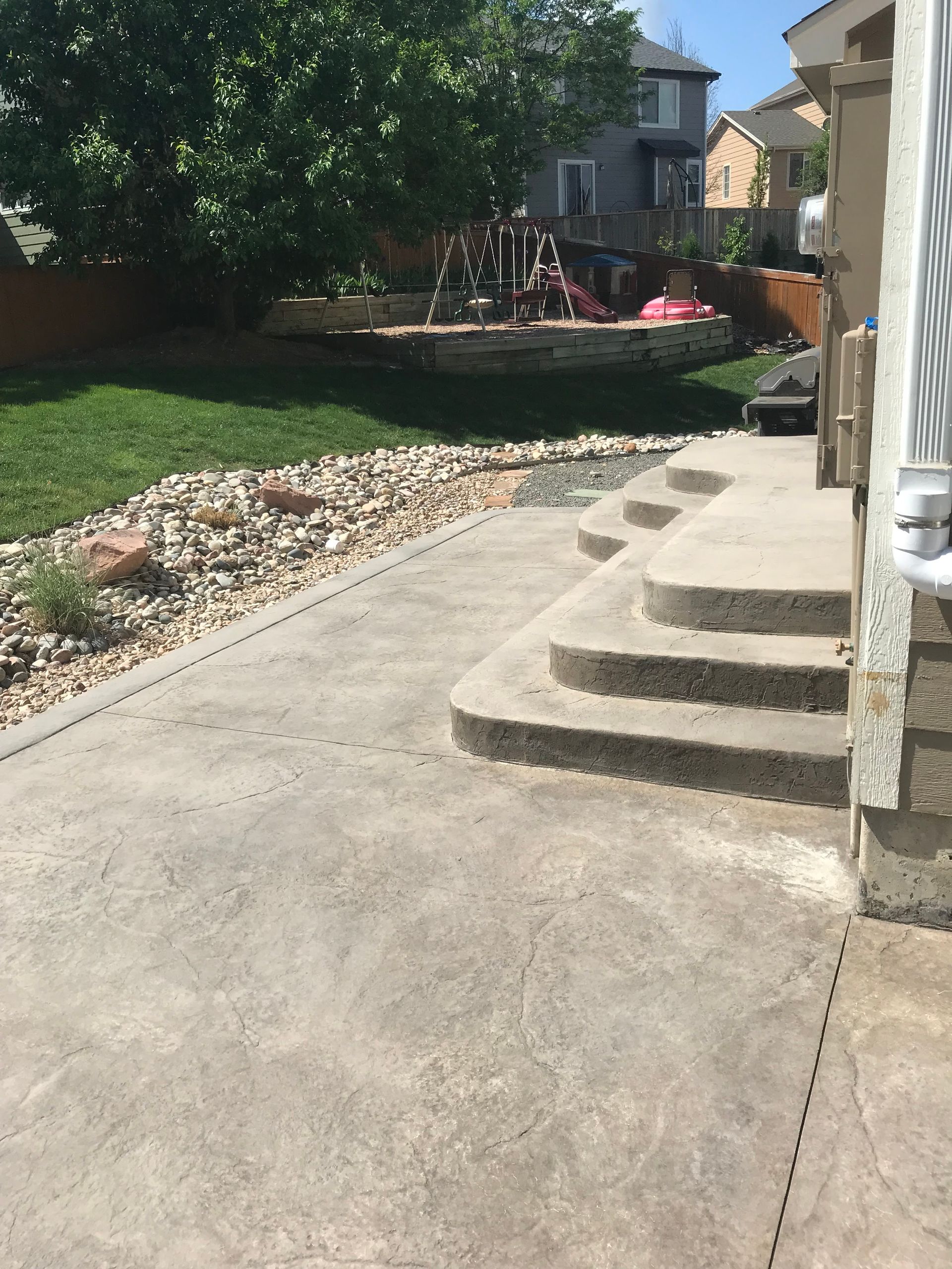 A concrete patio with stairs leading up to a house
